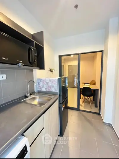 Modern kitchen with sleek design and open layout leading to dining area.