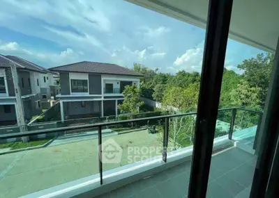 Spacious balcony with serene view of modern houses and lush greenery.