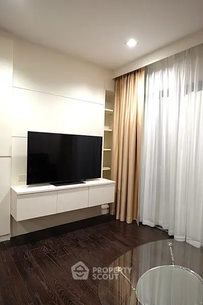 Modern living room with sleek TV setup and elegant curtains