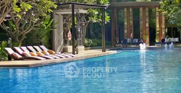 Luxurious outdoor pool area with sun loungers and lush greenery, perfect for relaxation and leisure.