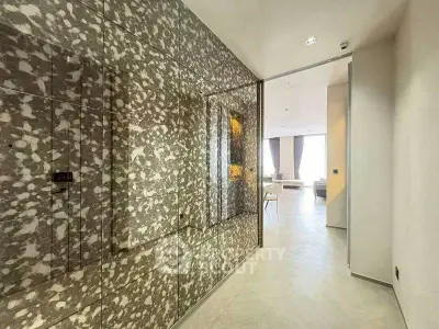 Luxurious modern hallway leading to a spacious living room with elegant decor and natural light.