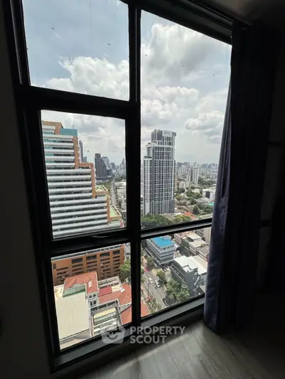 Stunning cityscape view from a high-rise apartment window, showcasing urban skyline and vibrant city life.