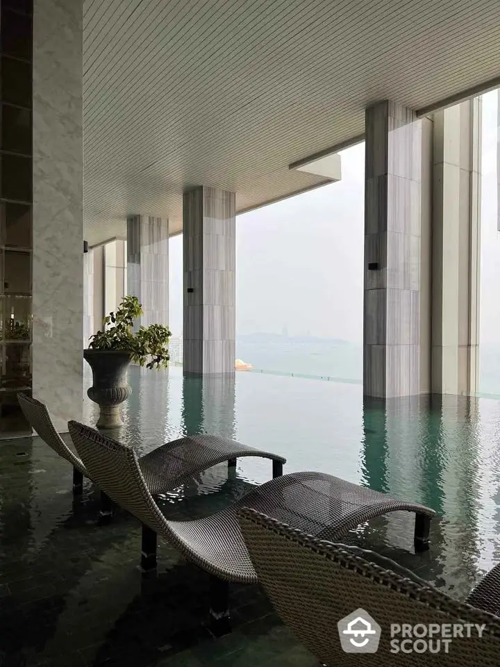 Luxurious indoor pool with stunning city view and elegant lounge chairs