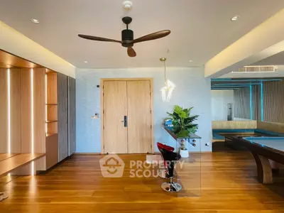Modern living room with wooden flooring, stylish ceiling fan, and elegant lighting.