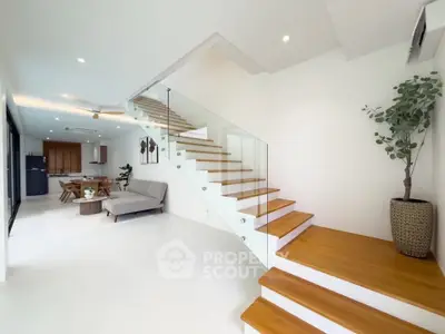 Modern open-plan living room with stylish staircase and elegant decor