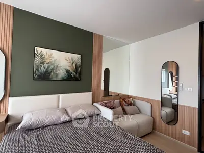 Modern bedroom with stylish decor and cozy seating area, featuring elegant mirrors and a nature-themed artwork.