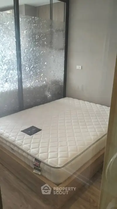 Modern bedroom with stylish glass partition and comfortable mattress