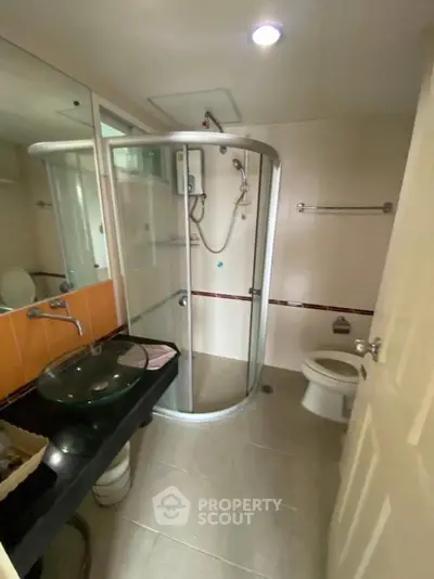 Modern bathroom with glass shower enclosure and sleek fixtures
