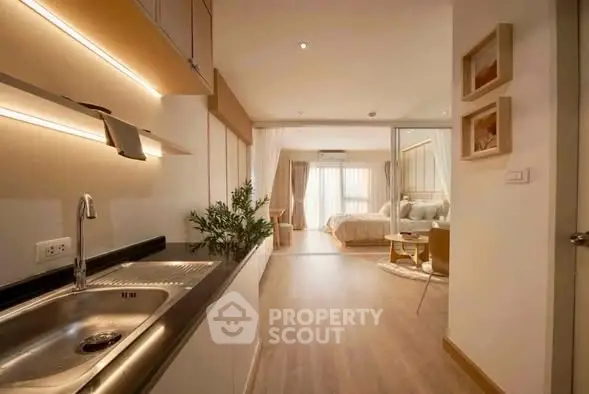 Modern open-layout apartment with sleek kitchen and cozy living area, perfect for urban living.