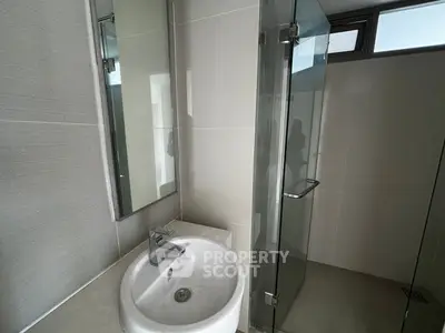 Modern bathroom with sleek glass shower and stylish sink in contemporary design.