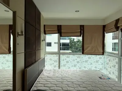 Modern bedroom with large windows and stylish blinds in a contemporary apartment.