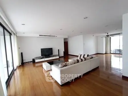 Spacious modern living room with sleek hardwood floors and large windows for natural light.