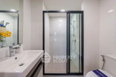 Modern bathroom with sleek shower and stylish sink in contemporary home.