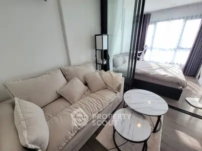 Modern apartment with cozy living room and bedroom, featuring stylish furniture and natural light.