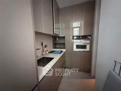 Modern kitchen with sleek cabinetry and built-in appliances in a compact layout.