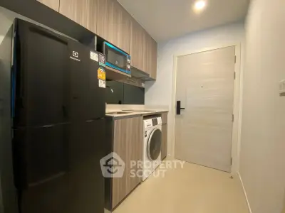 Modern kitchen with sleek appliances and stylish cabinetry in a compact layout.