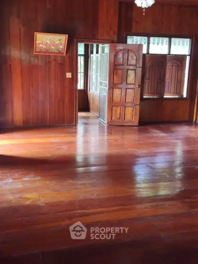 Charming wooden interior with polished floors and open doorway, perfect for cozy living.