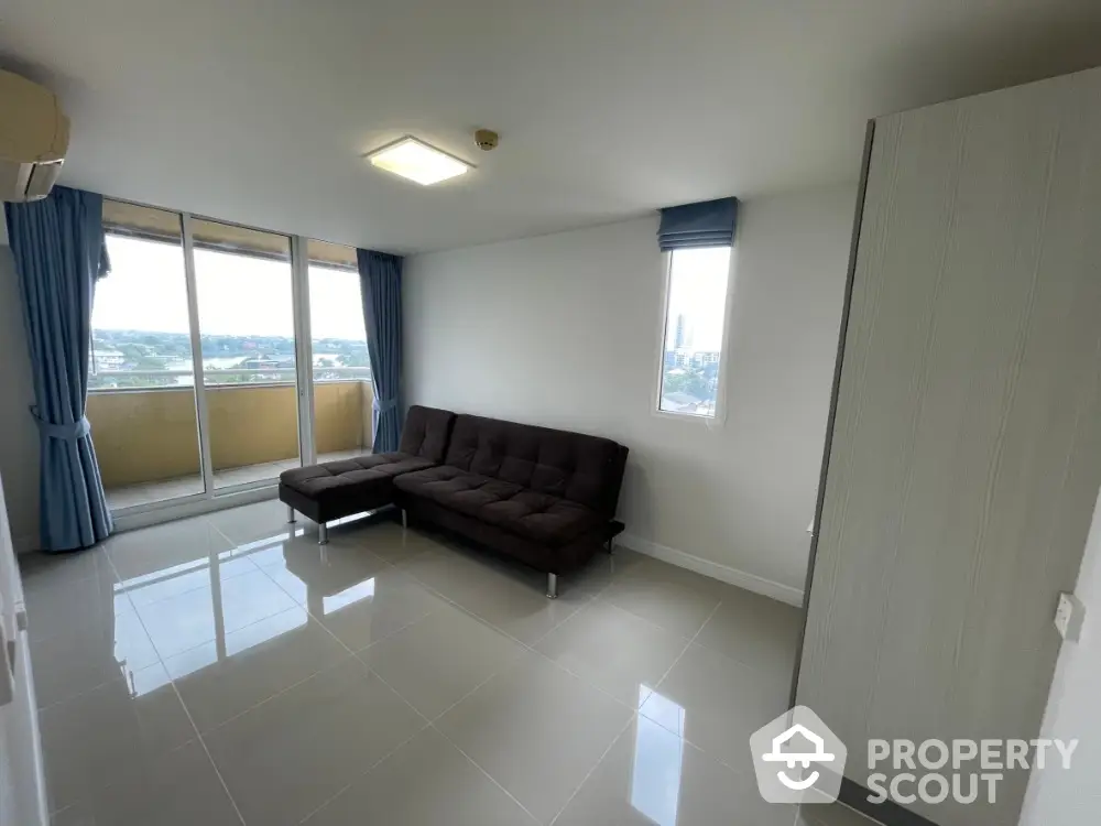 Modern living room with large windows and city view, featuring sleek tile flooring and contemporary furniture.