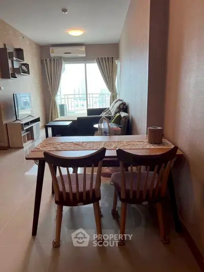 Modern living room with stylish furniture and city view balcony in a high-rise apartment.