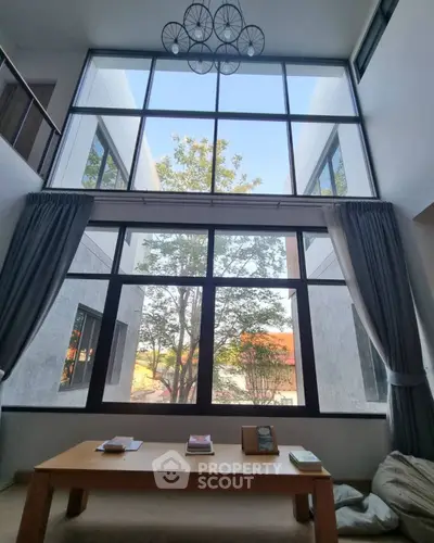 Stunning double-height living room with large windows and modern decor