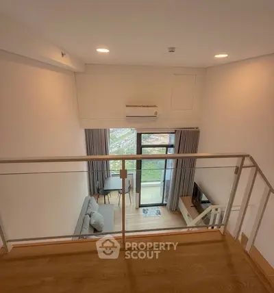 Modern loft apartment with balcony and large windows offering a stunning view.