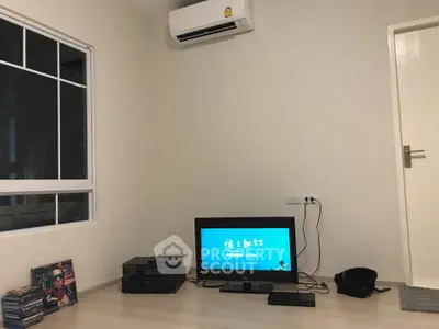 Minimalist living room with air conditioning and entertainment setup, ideal for cozy relaxation.