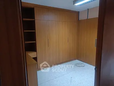 Spacious storage room with wooden cabinets and ample shelving