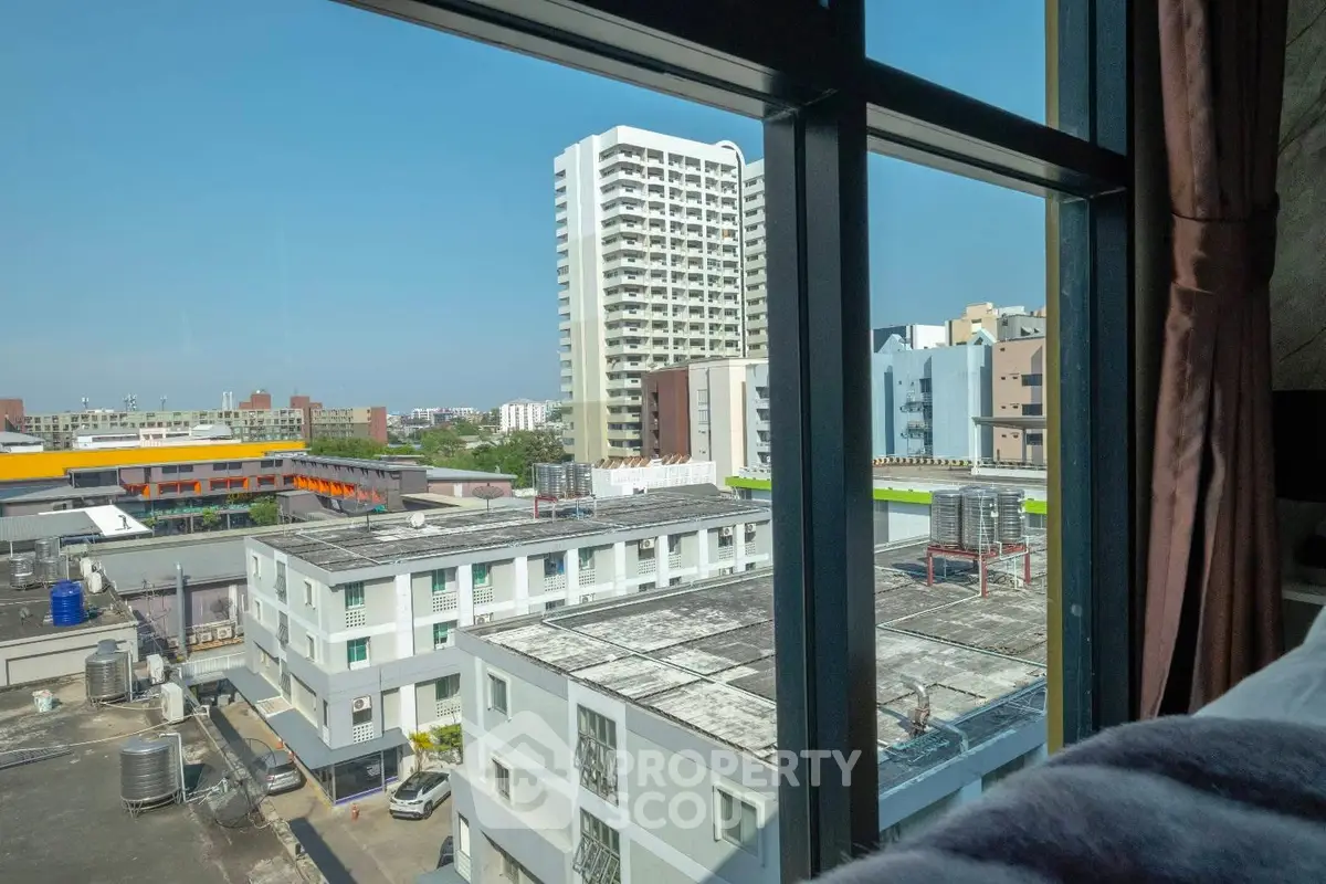 Stunning urban view from high-rise window showcasing cityscape and modern architecture.