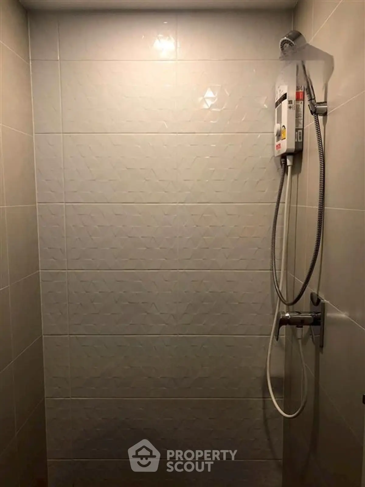 Modern bathroom shower with sleek tile design and water heater unit.