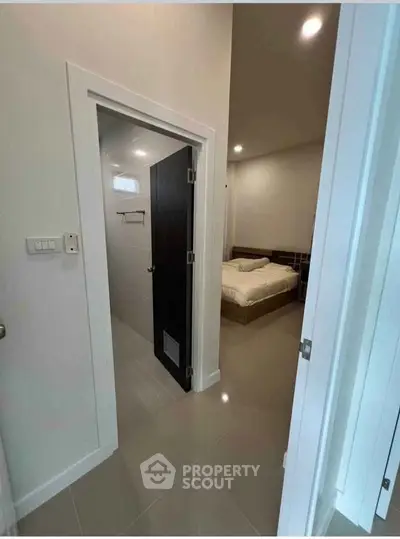 Modern bedroom with ensuite bathroom and sleek tile flooring