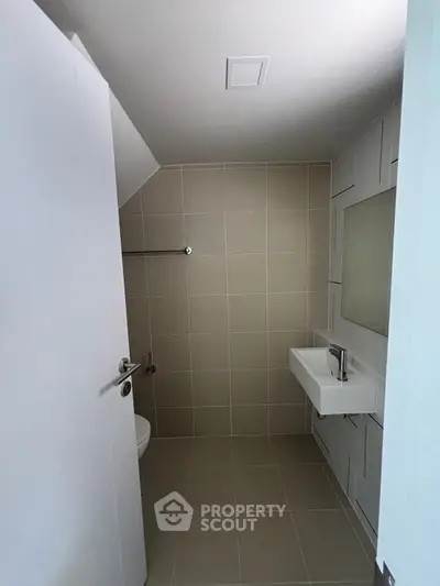 Modern minimalist bathroom with sleek fixtures and neutral tiles