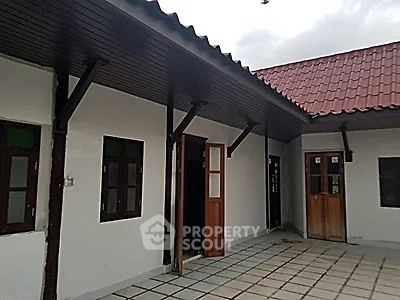 Charming single-story home with tiled patio and wooden doors, perfect for cozy living.