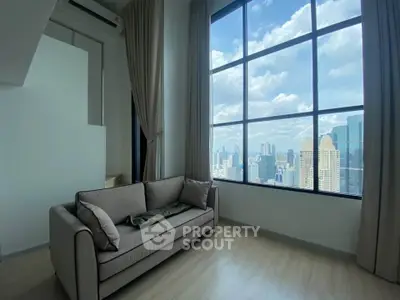 Modern living room with large window offering stunning city skyline view