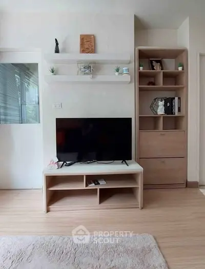 Modern living room with sleek TV stand and stylish shelving in cozy apartment.