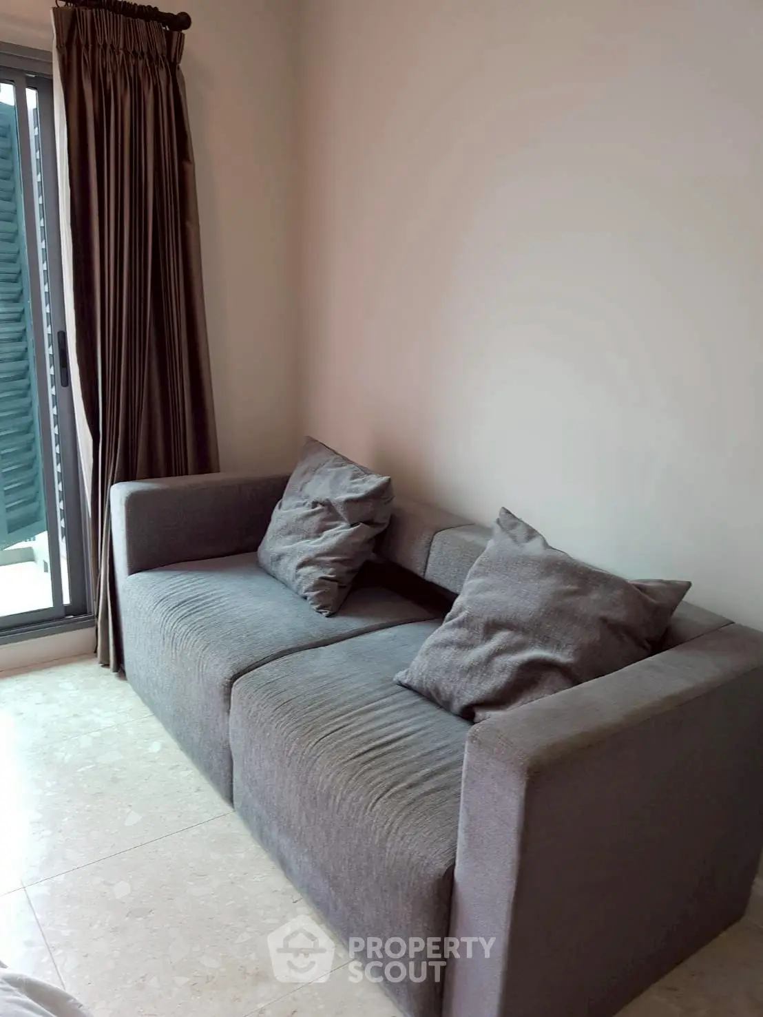 Cozy living room with modern gray sofa and natural light from window