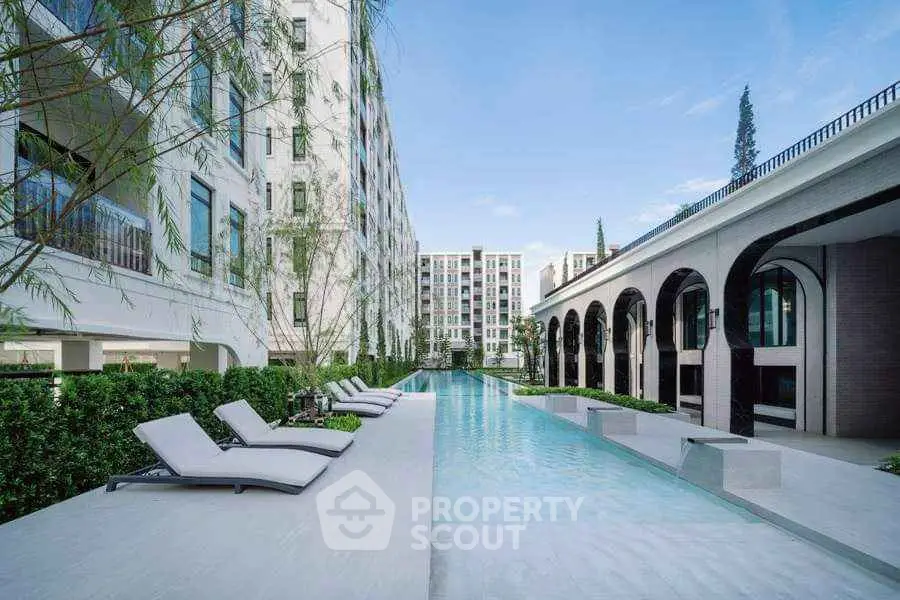 Luxurious modern apartment complex with stunning pool and elegant architecture.