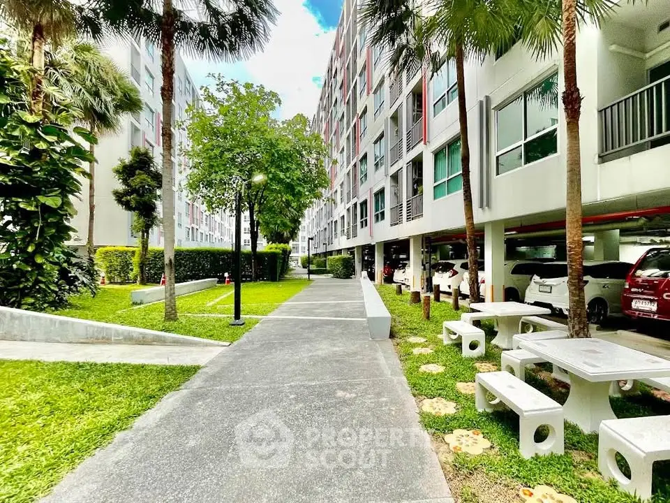 Modern apartment building with lush greenery and parking area