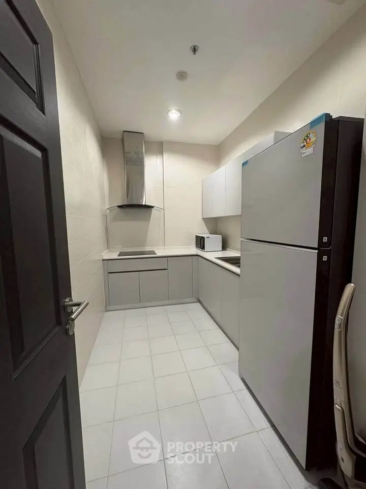 Modern kitchen with sleek cabinetry and stainless steel appliances in a compact layout.