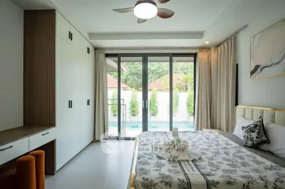 Spacious bedroom with pool view and modern decor in luxury home