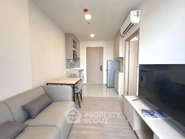 Modern living room with sleek furniture and integrated kitchen area in a stylish apartment.