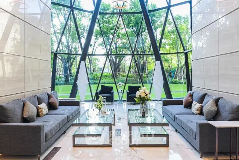 Luxurious living room with floor-to-ceiling windows and garden view, featuring elegant sofas and modern decor.