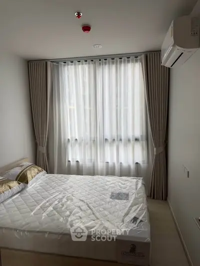 Modern bedroom with large window and air conditioning in a stylish apartment.