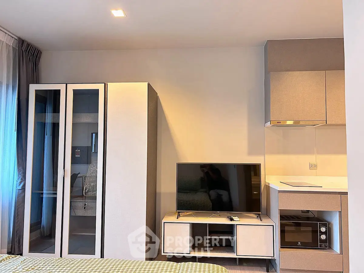 Modern apartment interior with sleek furniture and built-in kitchen appliances, perfect for urban living.