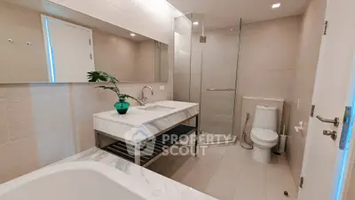 Luxurious modern bathroom with elegant marble finishes and glass shower enclosure.