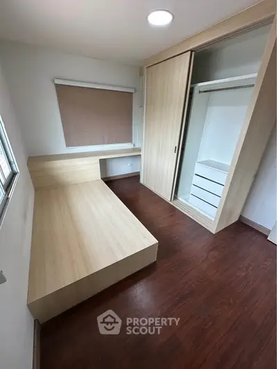 Modern bedroom with wooden flooring and built-in wardrobe