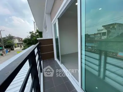 Spacious balcony with sliding glass doors and urban view