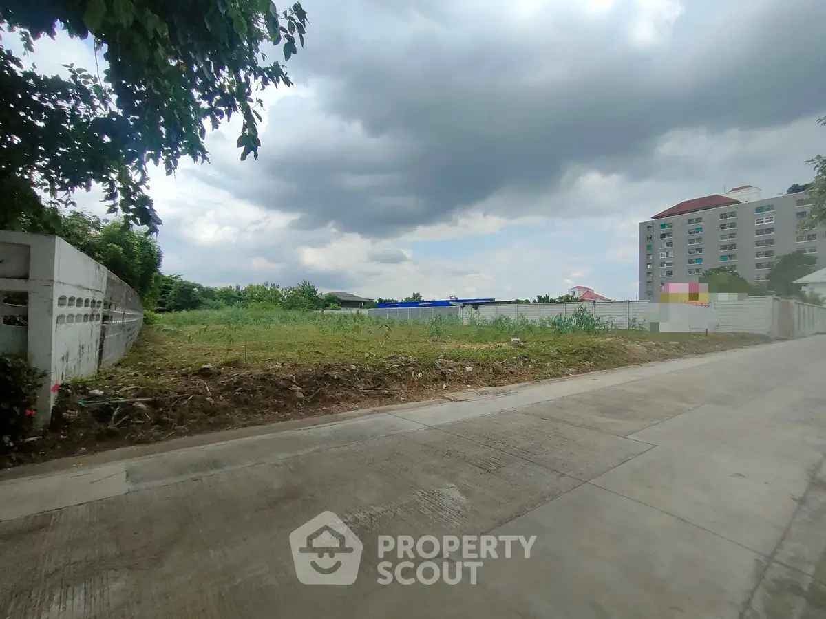 Vacant land plot with potential for development near residential building.