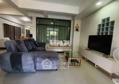 Spacious living room with modern furniture and large TV setup, perfect for relaxation and entertainment.