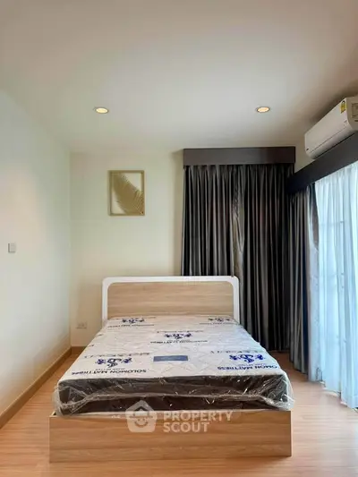 Modern bedroom with wooden flooring, stylish bed, and large window with curtains
