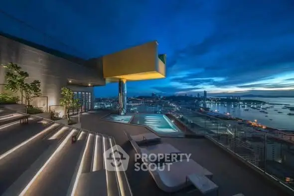 Stunning rooftop pool with panoramic city and ocean views at dusk.